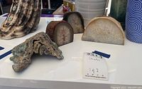Top view of four geode candle holders and one rock sample on a white surface, highlighting their shapes, crystal interiors, and textured outer surfaces.