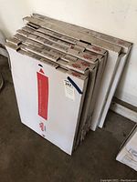 Photo of six boxed metal drawer frames and two boxed metal work surfaces stacked vertically.