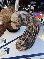Profile view of signed ceramic sculpture showing intricate black crackle patterns and overall shape.