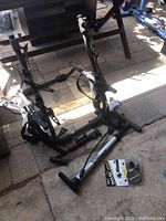 Vertical bike rack folded on ground with two hand bike pumps and small bicycle accessories visible