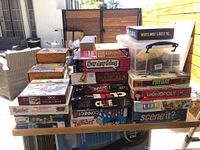 Photo of stacked boxed board games and card games on top of the wooden puzzle plateau
