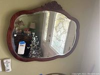 Full front image of vintage wall mirror showing rectangular shape with rounded edges and detailed carved wood frame.