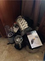 Overall lot showing four kitchen appliances including rice cooker wrapped in packaging