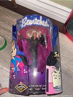 Front of original box showing Bewitched logo and visible doll in sparkly outfit with cape holding accessory