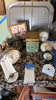 Full view of all timers, thermometers, and tea tin with additional kitchenware items.