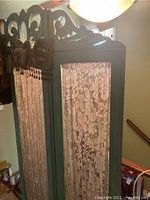 Side view of the vintage room divider showing lace fabric inserts and light blue wood frame.