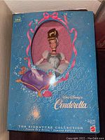 Front view of boxed Cinderella doll in blue Disney Signature Collection box with window showing doll's head and upper gown.
