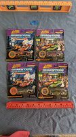 Four Johnny Lightning Dragsters New Year '98 die-cast cars in original packaging with ruler and level for scale. Each package includes a collectible display coin.