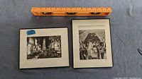 Overview of two framed black and white photos with ruler for size comparison. One shows Times Square, the other an aerial urban view.