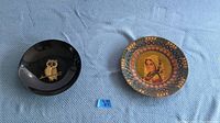 Two-piece lot view with Couroc owl serving bowl on left and decorative vintage plate on right
