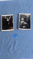 Pair of two black and white photographic postcards placed on blue fabric background for display