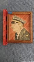 Frontal photo of the framed colored pencil sketch showing a security guard in uniform with measuring rulers for scale (approximately 7.5 inches tall by 6.5 inches wide).