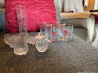 Overview of all glassware items including vase, glasses, sugar and cream set on couch