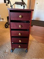 Front view of 5 drawer cabinet on caster wheels with some drawers slightly open.
