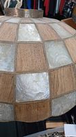 Close-up view showing alternating squares of translucent Capiz shell panels and natural bamboo wood squares on lampshade surface.
