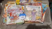 Photo showing a pile of colorful classic children's books including Clifford and Just Me and My Mom, with visible titles and covers.
