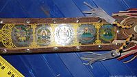 Full view of the painted steel belt showing design elements and leather sheath.