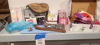 Wide shot showing all items in the lot including sleep mask, manicure kit, hair extensions, decorative butterflies, stones in pouch, incense holder, and personal care product boxes.