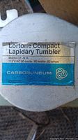 Label on Lortone Compact Lapidary Tumbler showing model number QT-N.R., electrical specifications, and Carborundum branding.