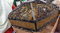 Top side perspective showing hexagonal shape with amber glass panels and wrought iron scrollwork.