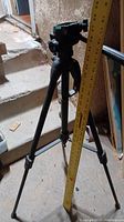 Ravelli fold-up tripod with expandable legs, approximately 38 inches tall, shown with measuring tape to demonstrate height.