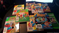 Photo showing 8 Archie comic books laid out, including Betty and Veronica Double Digest, Archie Double Digest, Jughead Double Digest, Archie Me Comic Digest. Covers show colorful character artwork.