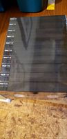 Top view of a box of 12 brand new sealed black blank VHS tapes labeled PLAY 7-30.
