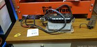 Dremel 2000 Electric sander polisher with attached cord and black top, resting on a surface next to a metal bug zapper device.