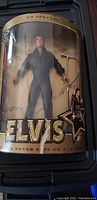 Elvis Presley '68 Special' 12-inch doll in box shown upright in packaging with background music notes and Elvis logo.