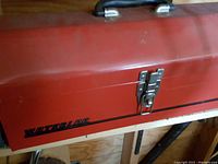 Close-up photo of the red metal Waterloo toolbox closed, showing latch and handle.