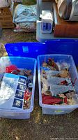 Two large blue plastic bins filled with various assorted Christmas decorations including ornaments and a Christmas calendar