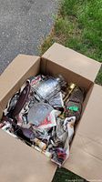 View of the box containing various wrapped decorative pieces, including metal and glass parts visible at the top