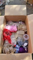 Top view of cardboard box with assorted glass and crystal glasses, wrapped in colorful protective cloth.