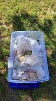 Photo of a plastic storage bin filled with assorted wrapped decorative items and knick knacks.