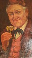 Close-up of the elderly man's face and glass portraying details of the painting.