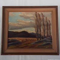 Frontal image of the framed oil painting showing the landscape scene including trees, hills, sky, and some frame damage.