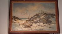 Full image of the framed oil painting showing coastal beach scene with boat and dunes