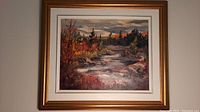 Full view of framed oil painting showing autumnal landscape with river, trees and cloudy sky