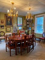 Dining table with six chairs arranged under chandeliers