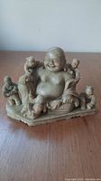 Front view of soapstone carving showing a happy man surrounded by five children.