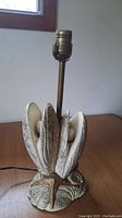 Full view of the ceramic seashell lamp missing a lampshade, showing the lamp base and socket.