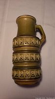 Full view of the tall West German pottery jug showing its shape, handle, and decorative embossed bands.