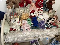Front view of the 2-seater light-patterned sofa with two white pull-out drawers underneath, assorted stuffed toys placed on top for scale and decoration.