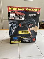 Box of Air Hawk Pro Automatic Cordless Tire Inflator showing product image and features like digital pressure gauge, cordless design, and suitable for car/SUV tires, sports equipment, and bike tires.
