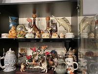 Glass cabinet shelves containing various ceramic and glass collectibles
