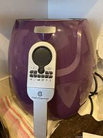 Front view of maroon Cook’s Essentials air fryer showing control panel with buttons and dial