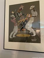 Photo showing framed Brazilian leather cut picture of three stylized figures playing instruments, signed by Evandro Rio 1971.