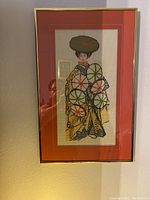 Full view of framed embroidered artwork showing an Oriental woman with parasols, mounted with a red mat and slim gold frame.