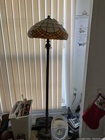 Full view of the stained glass floor lamp showing the entire height and base.