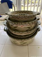 Stacked view of the 6 nested ovenware bowls showing exterior decorative pattern and handles.